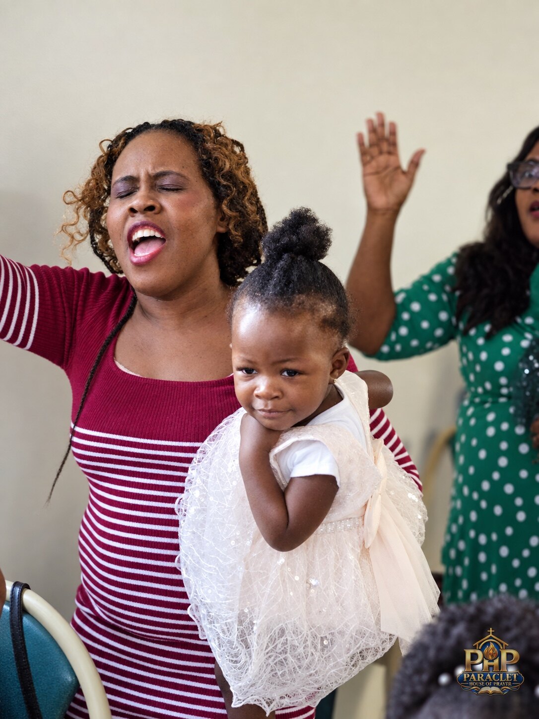 A worshiper praising God while holding a child