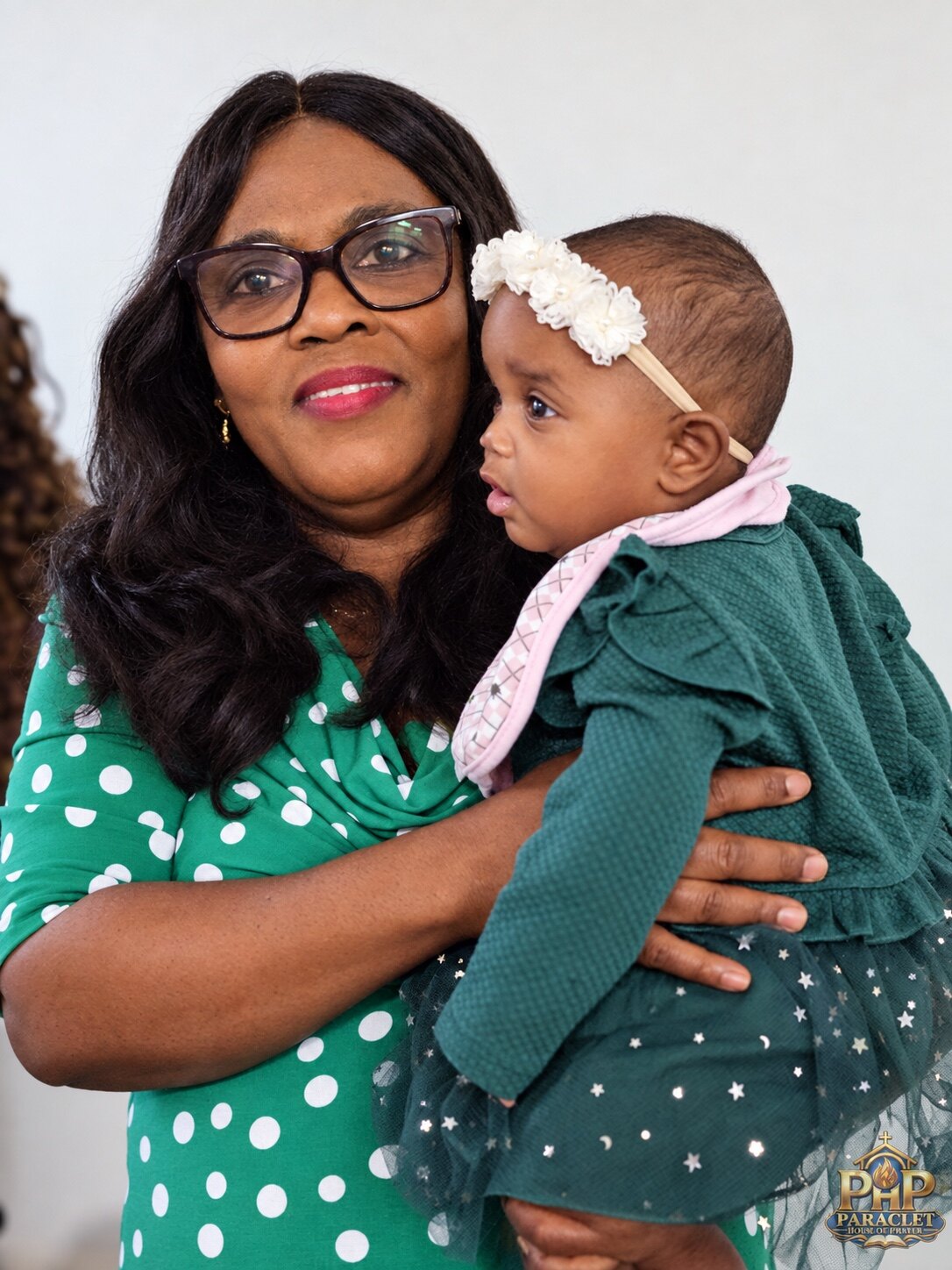 A woman holding a child during Sunday worship